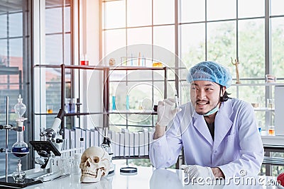 A successful male chemist is examining his new innovation in a laboratory. Stock Photo