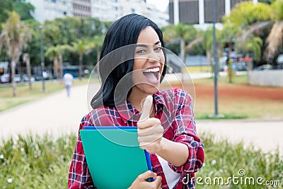 Successful native latin american female student showing thumb Stock Photo