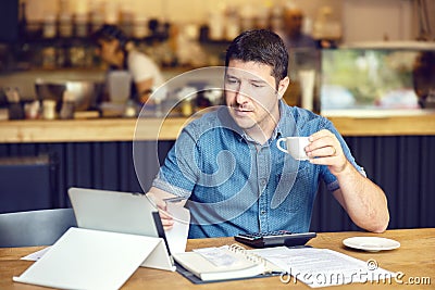 Successful new small business restaurant owner calculating bills taxes and expenses of his small business Stock Photo