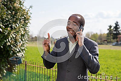 Successful positive african american businessman makes a phone call with a customer Stock Photo