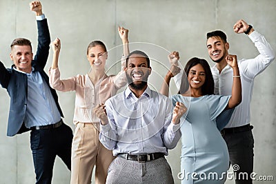 Successful Team. Group Of Multiracial Colleagues Celebrating Business Achievement With Raised Fists Stock Photo