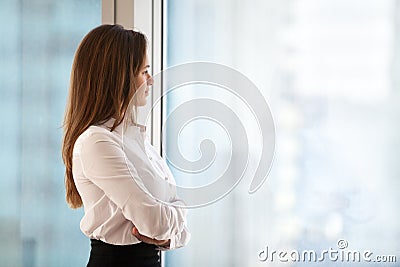 Successful thoughtful woman business leader looking out of big w Stock Photo