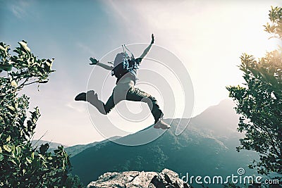 Woman jumping on cliff`s edge Stock Photo