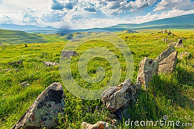 Succulent green field with stones in Armenia against the backdrop of mountains, Zorats Karer, Armenian Stock Photo