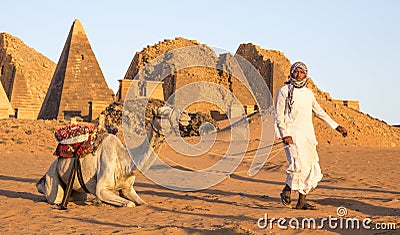 Sudanese man with his camel in a desert near Meroe Pyramids Editorial Stock Photo