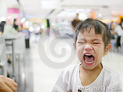 A sudden uncontrollable burst of crying of an Asian baby girl in a shopping mall Stock Photo