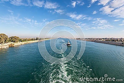 Suez Canal in Egypt. Tugboat accompanies the ships. Stock Photo