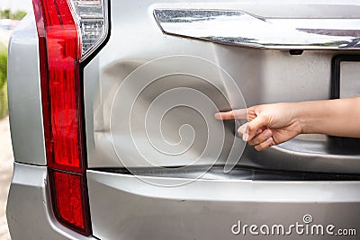 Sufferer hand point of vehicle car bumper dented broken from col Stock Photo