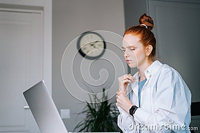 Suffering young redhead business woman having wrist pain during working at laptop computer Stock Photo