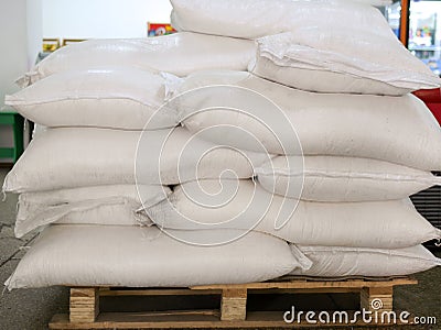 Sugar in bags, stacked on wooden pallet Stock Photo