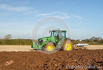 Modern John Deere tractor pulling a plough Editorial Stock Photo