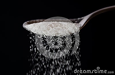 Close up of spoon pouring granulated refine white sugar Stock Photo