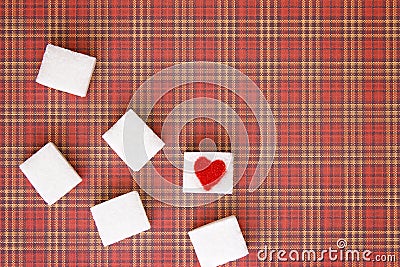 Sugar cubes with a red heart on one of them. Top view. Diet unhealty sweet addiction concept Stock Photo