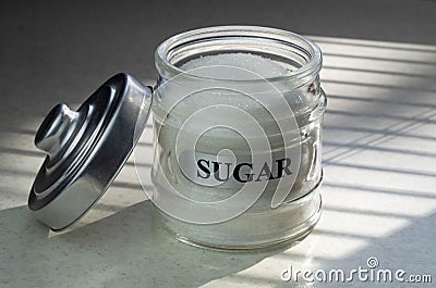 Sugar glass canister. White container with the word sugar in black font. Stock Photo