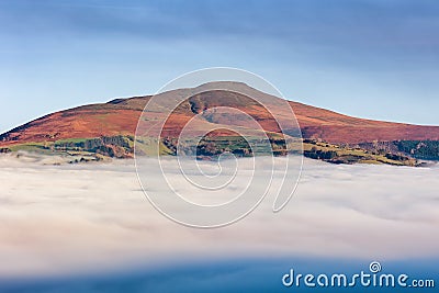 The Sugar Loaf mountain rising above fog and a cloud inversion Crickhowell, Wales Stock Photo