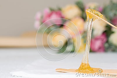 Sugar paste or wax honey for hair removing with wooden waxing spatula sticks - depilation and beauty concept Stock Photo