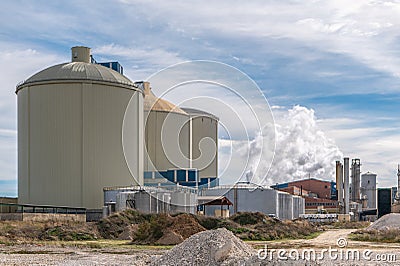Sugar production factory with chimneys expelling smoke outside Stock Photo