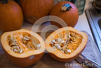 Sugar pumpkin cut in half exposing the pulp and seeds Stock Photo