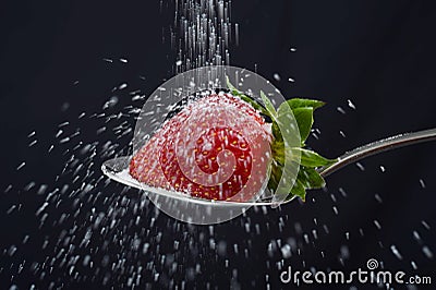 Sugar rain sprinkle over delicious strawberry on spoon spilling out everywhere Stock Photo