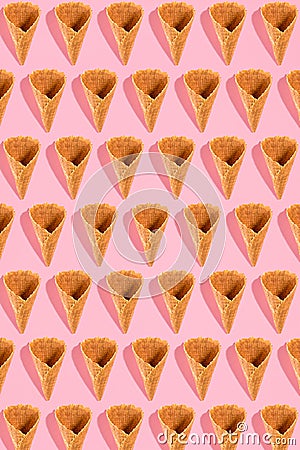 Sugar waffle cone for ice cream arranged in pattern on pink background. The image with copy space can be used as a Stock Photo