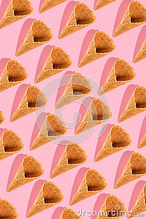 Sugar waffle cone for ice cream arranged in pattern on pink background. The image with copy space can be used as a Stock Photo