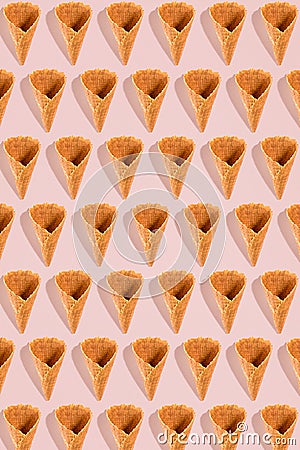 Sugar waffle cone for ice cream arranged in pattern on pink background. The image with copy space can be used as a Stock Photo