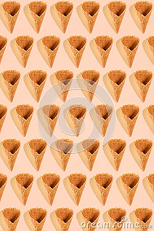 Sugar waffle cone for ice cream arranged in pattern on pink background. The image with copy space can be used as a Stock Photo