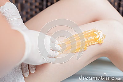 Sugaring epilation skin care with liquid sugar at legs Stock Photo