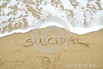 SUICIDAL written on sand Stock Photo