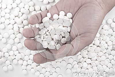 Suicide Pills, Pills, tablets in dead man`s hand by overdosing on medication. Top view close up of overdose pills on white backgr Stock Photo