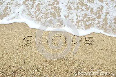 SUICIDE written on sand Stock Photo