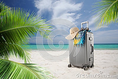 suitcase with hat, pareo and sunglasses on sunny tropic beach Stock Photo
