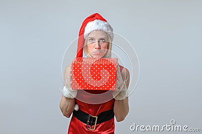 Sulking woman holding a Christmas gift. Stock Photo