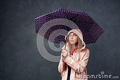 Girl in raincoat from rain, holding an umbrella Stock Photo