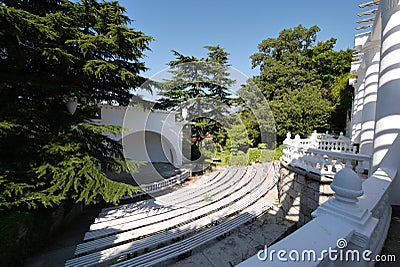 Summer amphitheater with several rows of benches, a spacious white balcony and a large stage Stock Photo