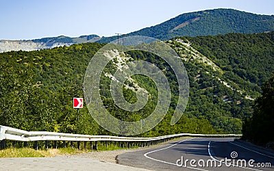Summer asphalt road in the mountains, leading over the hill. Stock Photo