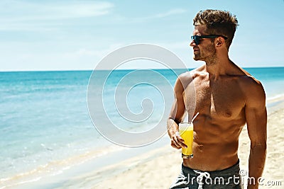 Summer. Athletic Muscular Man Drinking Juice Cocktail On Beach Stock Photo