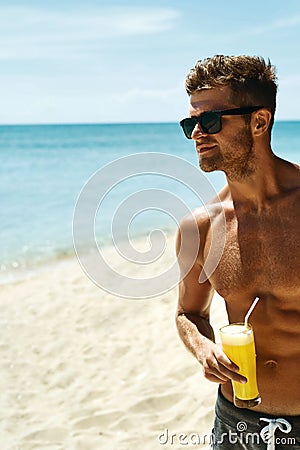 Summer. Athletic Muscular Man Drinking Juice Cocktail On Beach Stock Photo