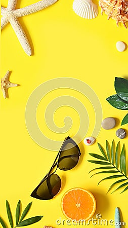 Summer background. Palm leaf, orange, starfish and seashell on yellow background. Travel. Stock Photo