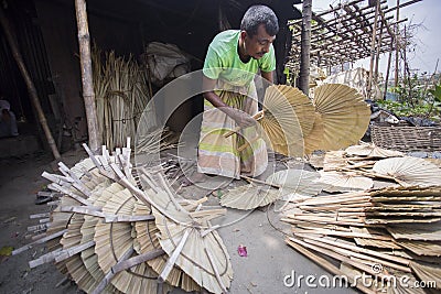 A worker is busy in making hand held fan. Editorial Stock Photo