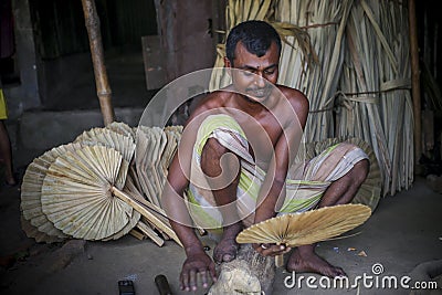 A worker is busy in making hand held fan. Editorial Stock Photo