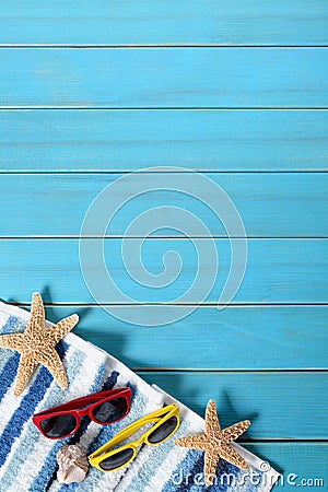 Summer beach background border, sunglasses, towel, starfish, blue wood copy space, vertical Stock Photo