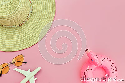 Summer beach composition. Minimal simple flat lay with plane sunglasses hat and Inflatable flamingo isolated on pastel pink Stock Photo