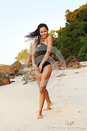 Summer Beach Fashion. Woman In Black Swimsuit On Sand Coast Stock Photo