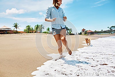 Summer Beach Fun. Woman Running With Dog. Holidays Vacations. Summer Stock Photo