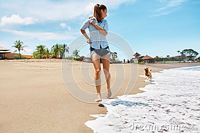 Summer Beach Fun. Woman Running With Dog. Holidays Vacations. Summer Stock Photo