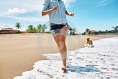 Summer Beach Fun. Woman Running With Dog. Holidays Vacations. Summer Stock Photo