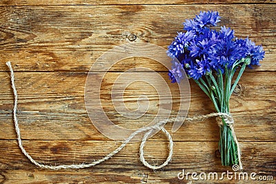 Summer bouquet cornflowers tied rope on wooden table Stock Photo