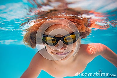 Summer child boy relax at aquapark. Summertime vacation. Little kid swim underwater in pool. Kid wearing summer goggles Stock Photo