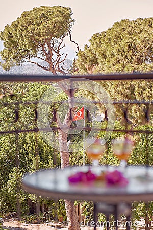 Summer cocktails and pink flowers of bougainvillea in front of turkish flag and mountains. Travel Turkey concept Stock Photo